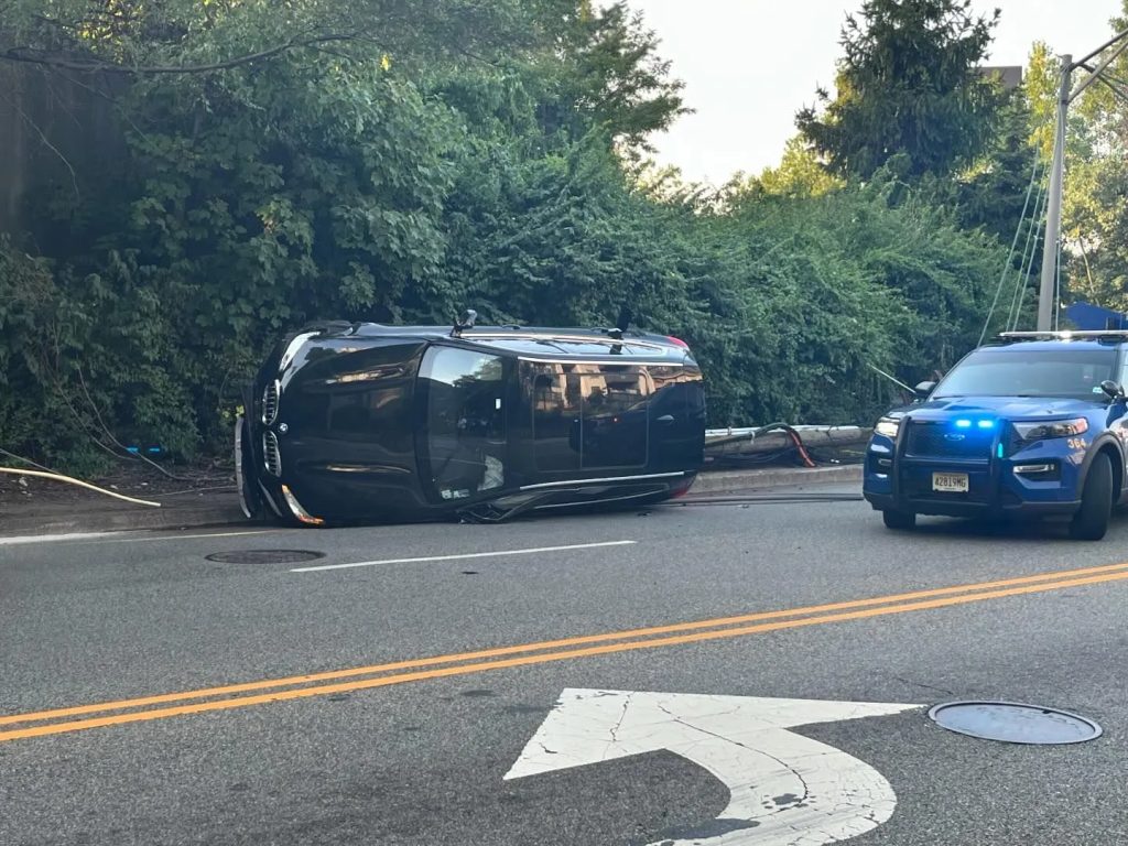 A black car leaned on its side following a rollover crash in Hackensack